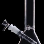 Clear glass bong with a flared base and angled neck, isolated on a black background.
