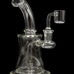 Clear glass water pipe (rig) with a quartz banger, isolated on a black background.