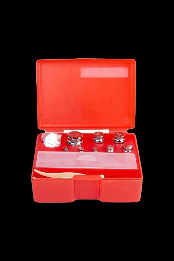Red calibration weights in a plastic case, used for precision scales often associated with cannabis measurement.