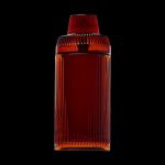 Amber glass cannabis storage jar with ribbed texture, isolated on a black background.