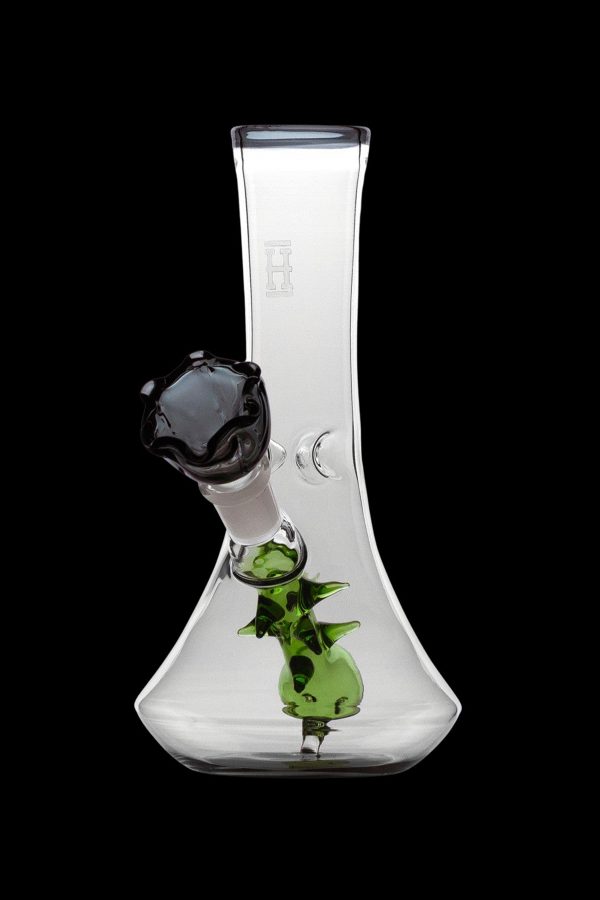 Clear glass bong with green sculpted accents and a black mouthpiece, isolated on a black background.