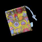 A drawstring bag with a psychedelic mushroom and floral pattern, likely used to store cannabis accessories.