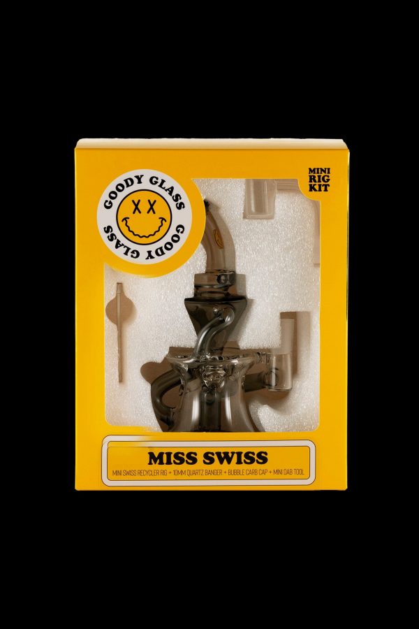 A retail box for "Goody Glass" cannabis accessories, showcasing a brown glass "Miss Swiss" mini rig kit with tools inside.