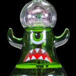 Green glass monster-themed rig with colorful accents, isolated on black.