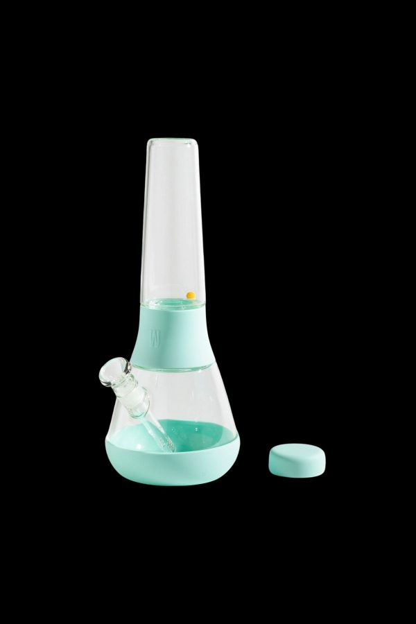 Mint green glass bong with silicone accents and cap, isolated on a black background.